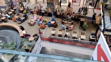 Chisinau, Moldova - 22 Kasım 2022: İnsanlar, erkekler ve kadınlar bir kahve dükkanında kahve içiyorlar. Alışveriş merkezi MallDova 'daki kahve dükkanının yukarıdan görünüşü