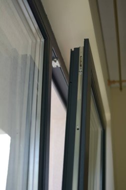 Plastic opened panoramic window in room at apartment, selective focus, shallow depth of field. Window details element. Panoramic windows of the apartment.