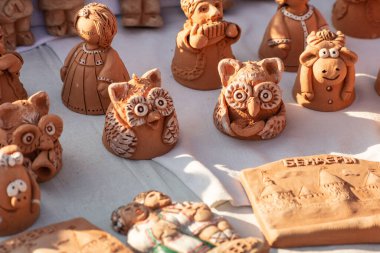 Moldova 'daki el sanatları fuarında sonbahar güneşinin ışınlarında el yapımı kil hayvan figürleri, el yapımı baykuş. Seçici odak, yüzeysel alan derinliği