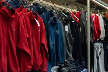 Chisinau, Moldova - 6 Ekim 2022: Bir mağazadaki askıda eşofmanlar. Metro Cash Carry mağazasında renkli eşofmanlar, spor giyim departmanı, seçici odak, sığ alan derinliği