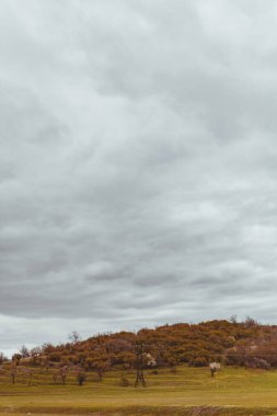 Tepelerin arkasında elektrik hattı ve kasvetli bir gökyüzü. Moldova 'nın manzaraları. Sanatsal fotoğraf işleme