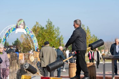 Bendery, Moldova - 12 Kasım 2022: kütük güreşi oyunu. Maslenitsa bayramındaki şenlikler. Oyunun amacı diğerini kayıt dışı tutmaktır..