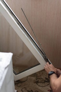 PVC pencerelerinin tamiri. Bir işçi eski bir pvc pencere mekanizmasını söker. Seçici odak, yüzeysel alan derinliği.