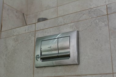 Otel banyosunda sifonu çekmek için modern çift düğme. Seçici odak, yüzeysel alan derinliği