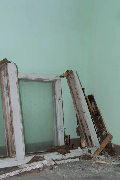 Replacement of old windows. Replacement of old wooden windows with plastic PVC ones. Old wooden window frames on the site of an apartment building. Installation
