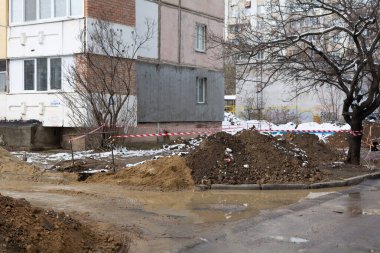 Tiraspol, Moldova - 9 Aralık 2023: Kanalizasyon PVC boruları döşeme. Kanalizasyon boruları döşemek için siperler hazırlandı, güvenlik bandıyla çitlendi. Seçici odak, yüzeysel alan derinliği