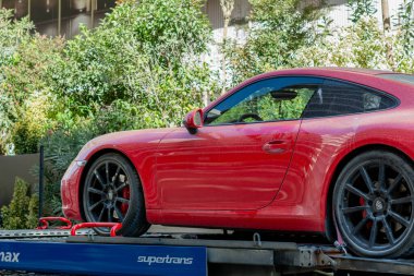 Mamaia, Constanta, Romanya - 8 Eylül 2023: Plaj kumuyla kaplı kırmızı Ferrari, çekici kamyon platformunda duruyor