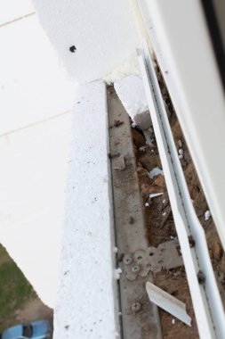 Yalıtım malzemesi. Ön cephenin metal çerçevesine bağlı köpük plastik panel. Köpük plastik panelli bir apartmanın dış cephesinin yalıtımı. Seçici odaklanma. Sığ alan derinliği.