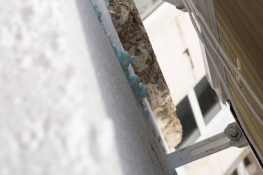 Köpük bağlanıyor. Bir panelin ön cephesinin köpük plastikle yalıtılması. Seçici odak, yüzeysel alan derinliği