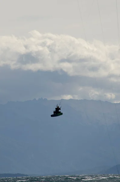 Кайтсерфинг Спортсмен Прыжки Кайтсерфинг Озере Горами Заднем Плане — стоковое фото