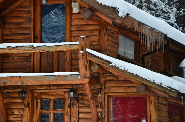 wooden cabin in winter, full of snow and with stalactites due to the intense cold