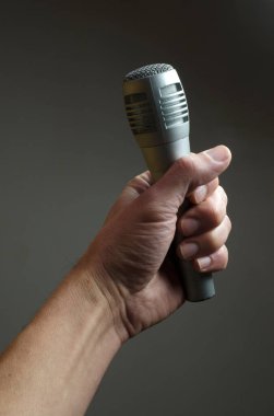 hand holding a microphone tightly. journalism and freedom of expression