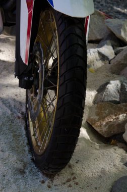 motorcycle wheel in the sand. enduro motorcycle cover with rim between sand and stone