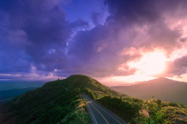 Dağdaki yalnız yolun gün batımı manzarası. Turuncu parıltılı dinamik bulut. Buyan Pavyonu, Shuangxi Bölgesi, New Taipei Şehri. Tayvan