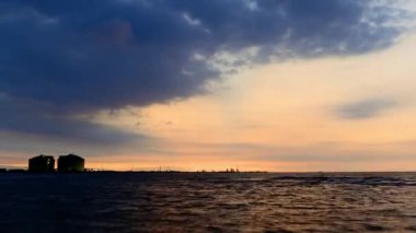 Deniz kenarında bir sanayi bölgesinin gün batımı manzarası. Mavi gökyüzü, turuncu akşam güneşi. Guanyin Endüstri Parkı, Taoyuan Şehri, Tayvan