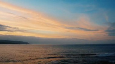 Alacakaranlıkta deniz kenarında. Turuncu bulutlu mavi gökyüzü. Waimushan Sahil Bölgesi, Keelung, Tayvan