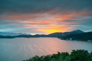 Kızıl bulutlarla gün batımının romantik manzarası. Güzel göller ve dağlar. Chaowu İskelesi, Sun Moon Gölü Ulusal Sahne Bölgesi. Nantou İlçesi, Tayvan