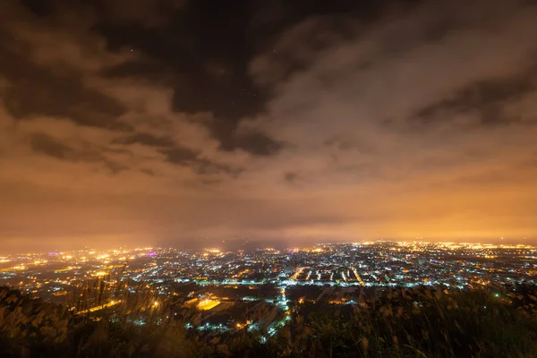 Hazy and dreamy night view of the city. The orange glow of the fog. A night view of the city shrouded in clouds. New Taipei, Taiwan