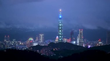 Dağlarla çevrili Taipei şehrinin puslu ve rüya gibi gece manzarası, 101 numaralı bina. Bulutlarla kaplanmış şehrin gece manzarası. Taipei, Tayvan