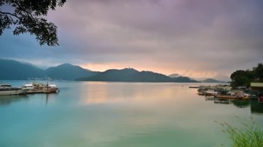 Kızıl bulutlarla gün batımının romantik manzarası. Güzel göller ve dağlar. Chaowu İskelesi, Sun Moon Gölü Ulusal Sahne Bölgesi. Nantou İlçesi, Tayvan