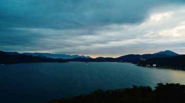 Kızıl bulutlarla gün batımının romantik manzarası. Güzel göller ve dağlar. Chaowu İskelesi, Sun Moon Gölü Ulusal Sahne Bölgesi. Nantou İlçesi, Tayvan