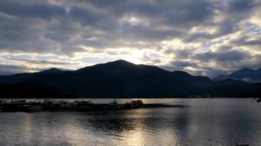 Gün doğumunun tam süreci. Güneş bulutların içine nüfuz eder. Chaowu İskelesi, Sun Moon Gölü Ulusal Sahne Bölgesi. Nantou İlçesi, Tayvan