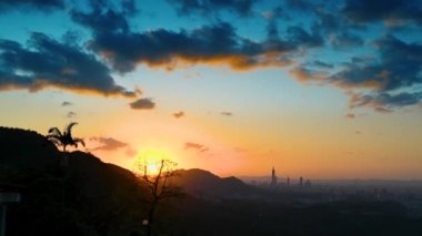 Gün batımında romantik ve muhteşem şehir manzarası. Turuncu gökyüzünde hareket eden bulutlar. Dağlarla çevrili şehrin gece manzarası sisli ve rüya gibi Taipei City, Tayvan
