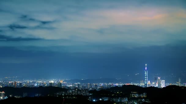 Pilvet Liikkuvat Taivaalla Öisin Neonvalot Loistavat Elinvoimaisessa Kaupunkimaisemassa Yönäkymä Kaupunkiin — kuvapankkivideo