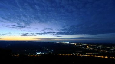 Gün batımında romantik ve muhteşem şehir manzarası. Mavi gökyüzünde hareket eden bulutlar. Şehrin puslu ve düş gibi alacakaranlık manzarası. Miaoli İlçesi, Tayvan