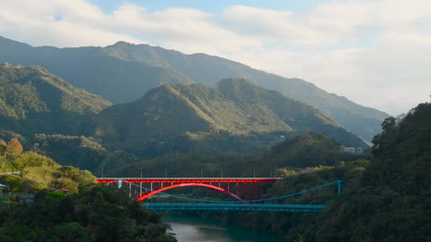 ストリーム上の美しい赤い橋 太陽は緑の山々に輝きます 保定橋は北恒高速道路に位置しています 台湾桃園市 — ストック動画