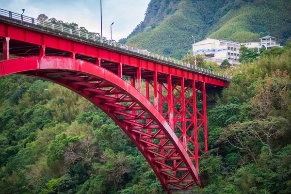 The beautiful red bridge over the stream. The sun shines on the green mountains. Baling Bridge is located on the Beiheng Highway. Taoyuan City, Taiwan