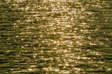 Güneş, parlak ışıkla gölün yüzeyinde parlar. Altın dalgalar gölde dalgalanıyordu. Meihua Gölü, New Taipei. Tayvan