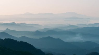 White clouds are among the mountains. There are tall buildings in the valley. Jiufen is an old mountain village. Ruifang District, New Taipei City, Taiwan