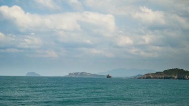 Yavaşça hareket eden bulutlar, berrak mavi gökyüzü, sakin dalgalar. Bu barışçıl bir tablo. İklim değişikliğine ve endüstriyel gelişime dikkat edin. Tayvan