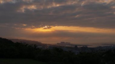 Crepuscular Ray ve hareket eden bulutlar gökyüzünde bir ışık ve gölge oyunu sahnelerler. İklim değişikliğine ve endüstriyel gelişime dikkat edin. Tayvan