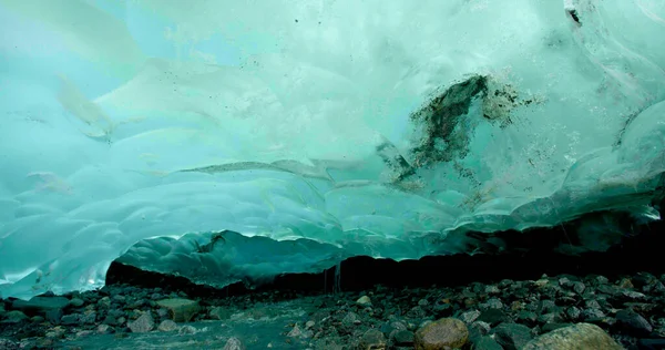 The ice under the rocks gradually melts and forms rivers. Turquoise ice. Exploring the Hidden Wonders of Alaska\'s Rock Ice Formation. USA., 2017