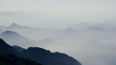 Göz kamaştırıcı alacakaranlık manzarası - canlı beyaz gökyüzü, dinamik bulutlar, sisli dağlar. Tayvan 'ın Jiufen kıyı köyünü çevreleyen Serene Okyanusu.