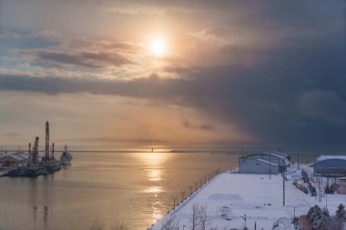 Alacakaranlıkta, kar kaplı iskele manzarasının huzurlu manzarasının tadını çıkarın. Hokkaido 'nun kışın huzurlu güzelliği: Kushiro Nehri boyunca huzurlu bir tekne gezisi.