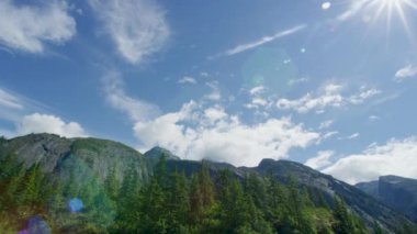 Dağ sırasının tepesinden güneşe doğru bir atış. Alaska 'da Yaz Macerası: Mavi Nehri Tekneyle Keşfedin.