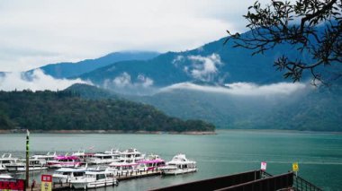 Muhteşem bulut şelaleleri dağlardan taşar. Göldeki tekneler. Sabah, Güneş Ay Gölü 'nün dağ ve göl manzarası. Nantou, Tayvan