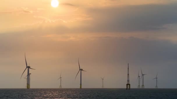 Wentylatory Turbin Wiatrowych Wirują Nad Musującym Morzem Pomarańczowo Czerwone Słońce — Wideo stockowe