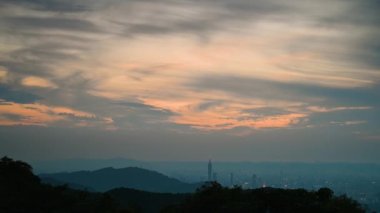 Alacakaranlıkta gökyüzü kararır ve şehrin ışıkları açılır. Taipei 'nin Muhteşem Akşam Görüşleri: Dinamik Bulutlar ve Şehir Manzarası.