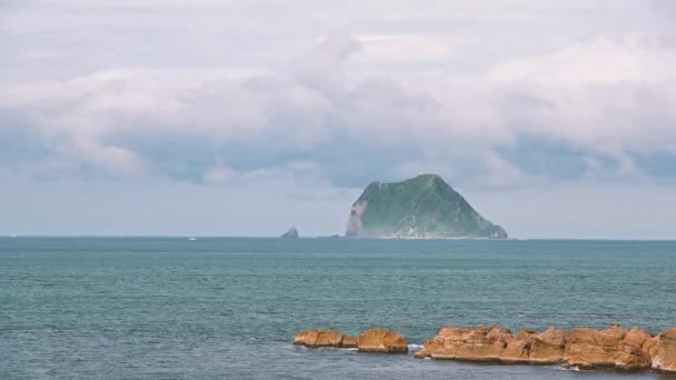 在岛上上空快速移动的云彩 船在蓝色的海面上航行 从新台北市万里海滩俯瞰基隆岛 — 图库视频影像