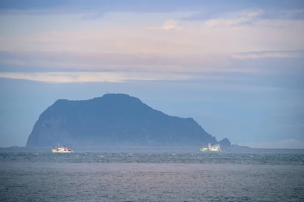 ボートは島の周りを航海する いくつかの霧とカラフルな雲です 新北市の万里ビーチから基隆島の景色 — ストック写真
