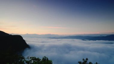 Güneş doğmadan önce dinamik bulut denizi. Kamera zumluyor. Dağların tepesindeki Beyaz Bulut Denizi 'nin hayranlık uyandıran manzarası. Tayvan
