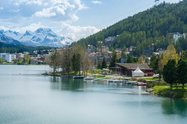 Snow-covered mountains, clear lakes, lakeside houses and coniferous forests. St. Moritz Retreat: Capturing the Scenic Landscapes of a Swiss Vacation Town.