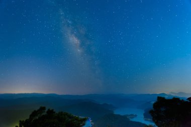 Galaktik Dinginlik: Dağ Zirvesinde Gece Ufku. Yazın New Taipei 'deki Timsah Adası' nda yıldızlı gökyüzü.