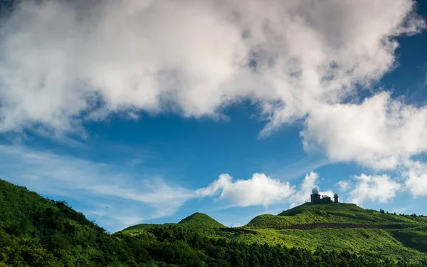 Mountain\'s Clear Day: Dynamic White Clouds Against a Blue Sky. The Wufenshan Weather Radar Station stands on the top of the mountain. Taiwan
