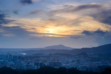 Gün batımında şehrin üzerinde beyaz dinamik bulutlarla mavi gökyüzü. Dajianshan Dağı 'ndan kentsel manzara, Yeni Taipei Şehri, Tayvan