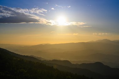 Güneş ufuktaki dağlara doğru hareket eder. Wufenshan Hava Radar İstasyonu dağın tepesinde duruyor. Tayvan